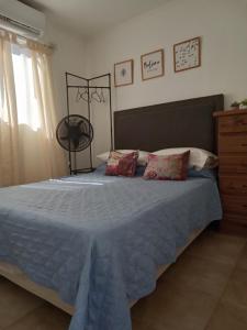 科连特斯WyW PEATONAL JUNIN的卧室里有一张铺着蓝色床单的床和一扇窗户