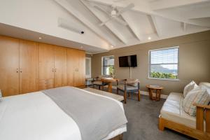 ein Schlafzimmer mit einem Bett, einem Fernseher und einer Couch in der Unterkunft Camps Bay Retreat Hotel in Kapstadt + 38 Fotos
