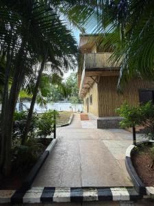 una pasarela frente a un edificio con palmeras en The Exotic Aura Resort, en Pondicherry