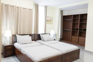 een slaapkamer met twee bedden en een groot raam bij BethelAirBnB in Winneba +16 foto's