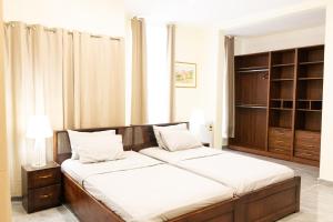 een slaapkamer met 2 aparte bedden en een kast bij BethelAirBnB in Winneba