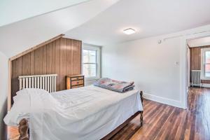 a bedroom with a bed and a wooden wall at Roomy Lancaster Home Walk to Dtwn and Hospital in Lancaster