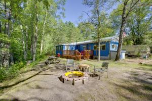 a blue trailer with a fire pit in front of it at Little Manistee Riverfront Cabin with Fire Pit! in Irons