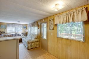 a kitchen and living room with a couch and window at Little Manistee Riverfront Cabin with Fire Pit! in Irons