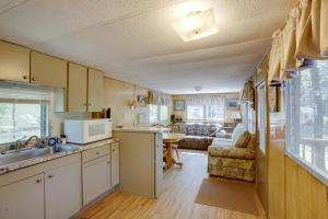 a kitchen and living room of a caravan at Little Manistee Riverfront Cabin with Fire Pit! in Irons +17 photos