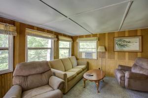 a living room with a couch and two chairs and a table at Little Manistee Riverfront Cabin with Fire Pit! in Irons