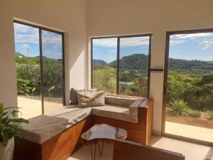 una camera con panchina di fronte alle finestre di Villa BotaNICA guest house a San Juan del Sur