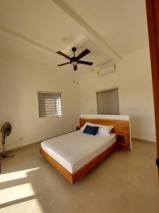 una camera da letto con un letto e un ventilatore a soffitto di Villa BotaNICA guest house a San Juan del Sur