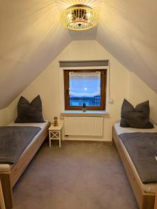 two beds in a attic room with a window at Ferienwohnung Grobbel in Schmallenberg