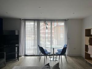 a dining room with a table and chairs in front of a window at Cozy Flat for 2 River of Thames with FREE Parking in Staines