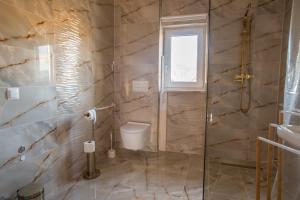 a bathroom with a shower and a toilet and a sink at Domki u Wojtka in Grywałd +44 photos