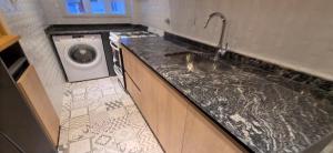 Alquileres Corrientes في مار ديل بلاتا: مطبخ مع حوض وغسالة ملابس +39 صورة