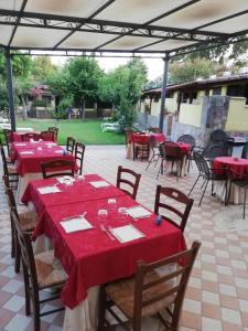 Eine Gruppe von Tischen mit roten Tischdecken auf einer Terrasse in der Unterkunft Hotel Villaggio Tabù in Palinuro