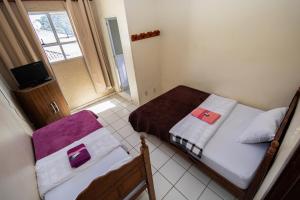 a small bedroom with two beds and a window at Pousada Zacarias in Ouro Preto