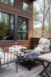 a patio with two chairs and a table with a bottle of wine at Forest Green Retreat in Brattleboro