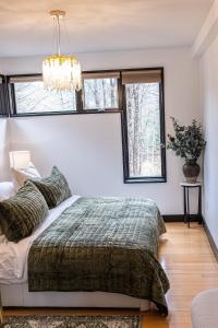 a bedroom with a bed and two windows at Forest Green Retreat in Brattleboro +14 photos