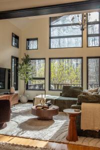 a living room with large windows and a couch at Forest Green Retreat in Brattleboro