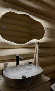 baño con lavabo en una pared de madera en Black Crest, en Vyshkiv