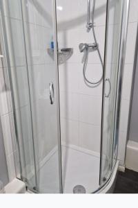 a bathroom with a shower with a glass door at Home Sweet Home, Calverley Court Apartment Home in West Midlands, England in Parkside