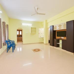 Bhakti Bliss Homestay - Spacious 2bhk AC Apartment near Padmavati Ammavari Temple in Tirupati في تيروباتي: غرفة معيشة مع كراسي ومروحة سقف +صورتان