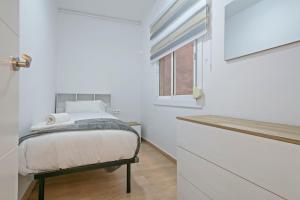 ein kleines Schlafzimmer mit einem Bett und einem Fenster in der Unterkunft Dialez Holidays - Colomeres in Gavà + 7 Fotos