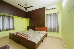 Bhakti Bliss Homestay - Spacious 2bhk AC Apartment near Padmavati Ammavari Temple in Tirupati في تيروباتي: غرفة نوم بها سرير ونافذتين
