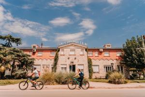 two people riding bikes in front of a building at San Pedro Hotel in Río Ceballos