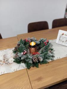 a christmas wreath on a table with a candle at Vila Veles in Dolný Kubín