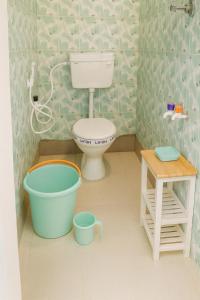 Bhakti Bliss Homestay - Spacious 2bhk AC Apartment near Padmavati Ammavari Temple in Tirupati في تيروباتي: حمام ألعاب مع مرحاض ودلال