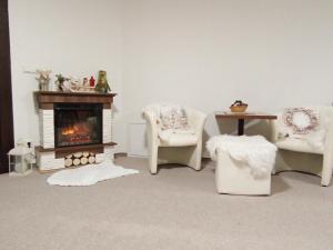 a living room with two chairs and a fireplace at Vila Veles in Dolný Kubín