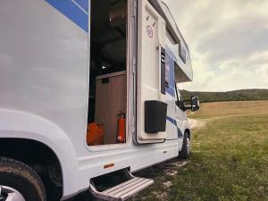 Un camión blanco estacionado en un campo con la puerta abierta en Tjaldstæði fyrir gistingu, en Reikiavik