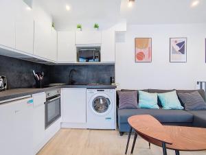 eine Küche und ein Wohnzimmer mit einer Couch und einer Waschmaschine in der Unterkunft Suite Feel Good - Appartement in Argenteuil + 4 Fotos