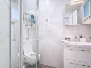 ein weißes Badezimmer mit Toilette und Dusche in der Unterkunft Suite Feel Good - Appartement in Argenteuil