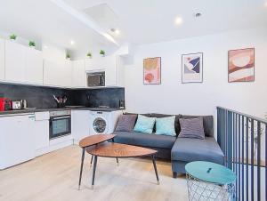 ein Wohnzimmer mit Sofa und Tisch in der Unterkunft Suite Feel Good - Appartement in Argenteuil