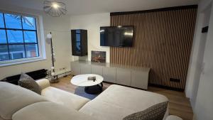 a living room with a white couch and a tv at Brück Residenz - 100qm Altstadtwohnung an der Steinernen Brücke in Regensburg