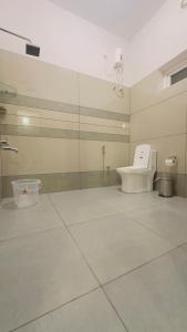a bathroom with a toilet and a glass wall at TAMARA VISTA Executive Homestay in Varkala +36 photos