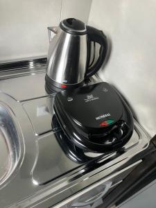 a tea kettle sitting on top of a stove at Panama 90 - Studio - Região Central in Poços de Caldas