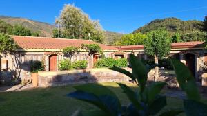 Ein Haus mit einem Garten, der von einem Zaun und Bäumen umgeben ist in der Unterkunft Hotel Villaggio Tabù in Palinuro