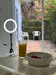 a glass of orange juice and a bowl of fruit on a table at Hotel Selva HQ in Palomino