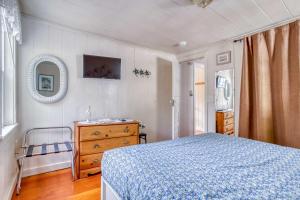 a bedroom with a bed and a dresser and a mirror at Cathys Cottage in Cannon Beach
