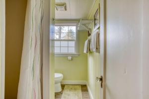 a bathroom with a toilet and a window at Cathys Cottage in Cannon Beach +31 photos