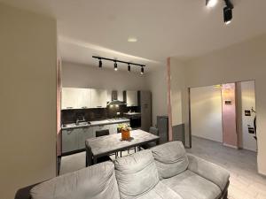 een woonkamer met een bank en een keuken bij One home in Salerno