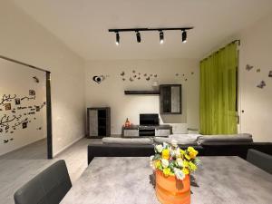 een woonkamer met banken en een tafel met bloemen bij One home in Salerno