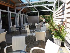 an outdoor patio with white chairs and tables at Pensiunea Play in Deva