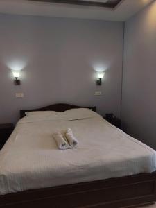 a bed with two pairs of slippers on it at Pahaad Ko Ghaar in Nagarkot