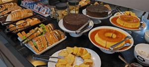 Una mesa cubierta con pasteles, tartas y otros postres en Abudi Hotel, en Cuiabá 56 fotos más