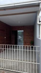 a fence in front of a house with a door at 900m praia, próximo Beto Carrero in Piçarras