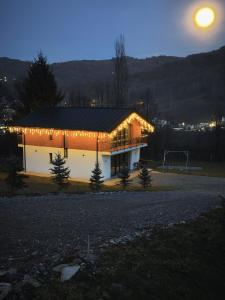 a house with lights on the side of it at night at EDEN HOUSE Viseu de Sus in Vişeu de Sus