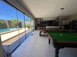 uma sala com mesa de sinuca e piscina em Linda casa com piscina - locação temporada em itapoá sc em Itapoa
