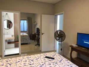 um quarto com uma cama, uma ventoinha e um espelho. em Linda casa com piscina - locação temporada em itapoá sc em Itapoa mais 24 fotografias